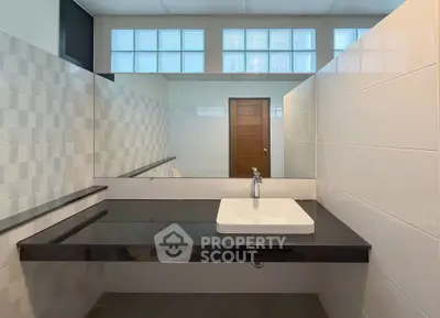 Modern bathroom with sleek black countertop and stylish sink in contemporary home.