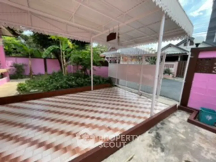 Charming outdoor patio with tiled flooring and garden view in a vibrant neighborhood.