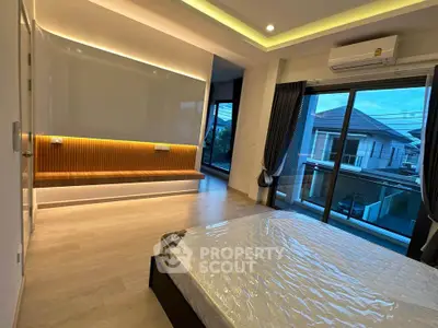 Spacious modern bedroom with large windows and balcony access in a luxury home.