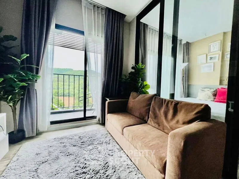 Stylish living room with cozy sofa and balcony view in modern apartment