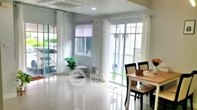 Bright dining area with modern decor and large windows in a stylish home.