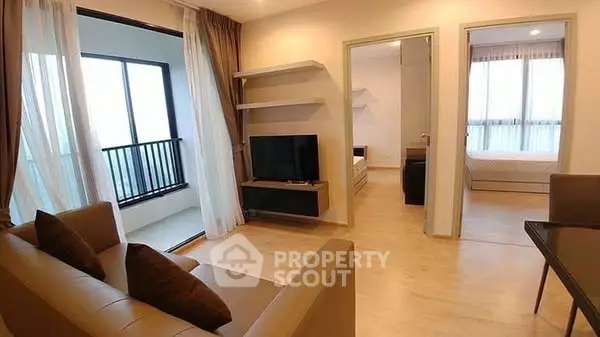 Modern living room with balcony access and cozy bedroom view