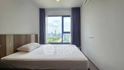 Spacious bedroom with stunning city view from large window, modern design and natural light.