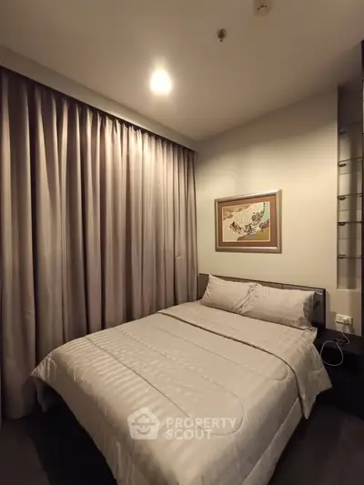 Cozy bedroom with elegant curtains and framed artwork, perfect for restful nights.