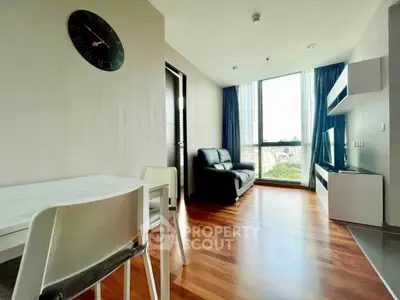 Modern living room with large window and stylish decor in urban apartment.