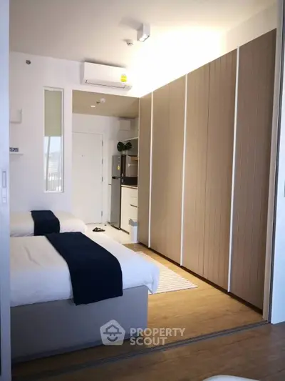 Modern bedroom with twin beds and sleek wardrobe in stylish apartment