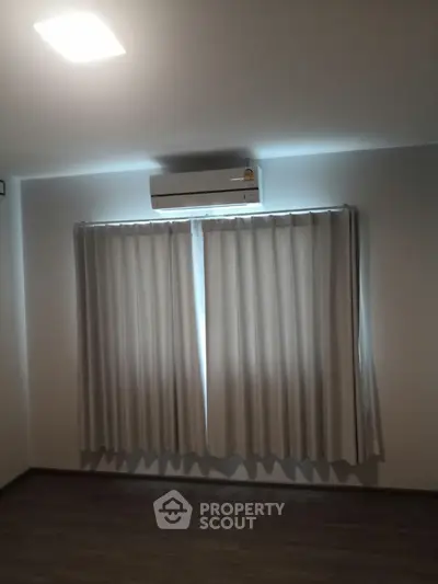 Minimalist room with air conditioning and curtains, perfect for cozy living.