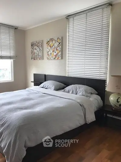 Cozy bedroom with modern decor and large windows for natural light.