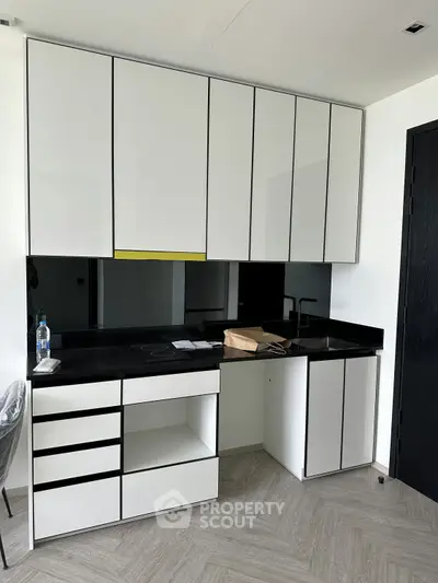 Modern kitchen with sleek black countertops and white cabinetry, perfect for contemporary living.