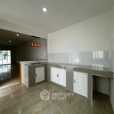 Modern kitchen with open layout and stylish lighting in a spacious apartment.
