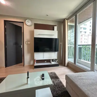Modern living room with large TV and balcony view in a stylish apartment.