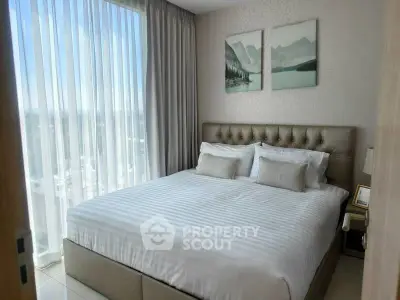 Elegant bedroom with large window and stylish decor in modern apartment
