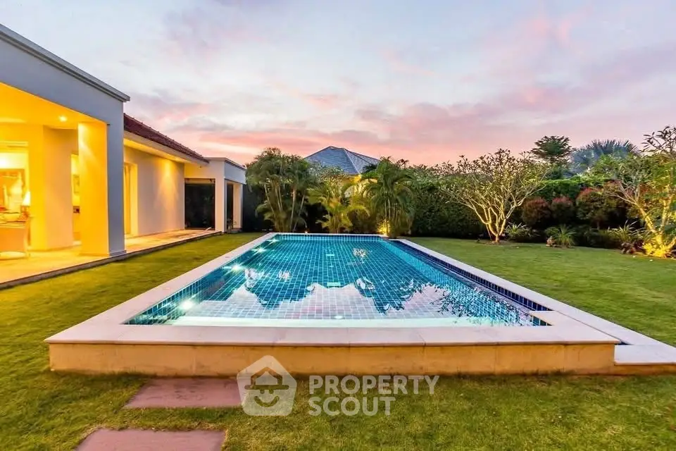 Luxurious villa with stunning pool and lush garden at sunset