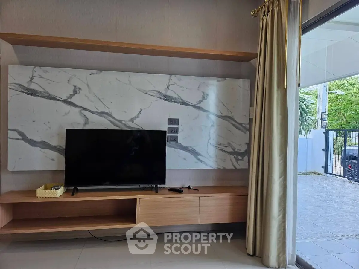 Modern living room with marble accent wall and sleek TV setup