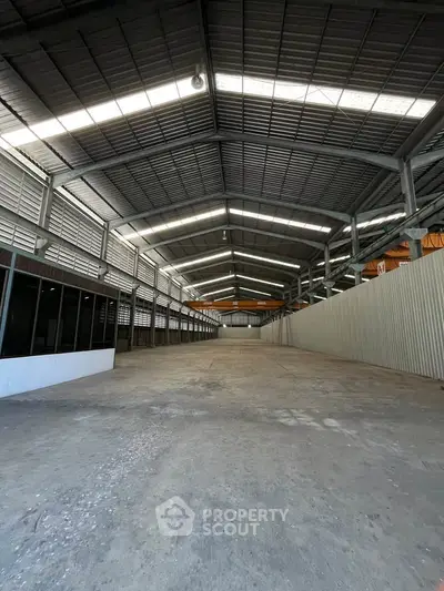 Spacious industrial warehouse with high ceilings and ample natural light.