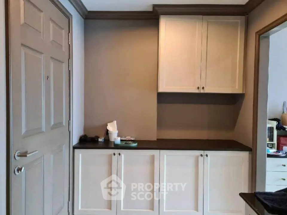 Charming entryway with built-in storage cabinets and elegant crown molding.