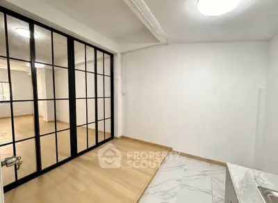 Modern interior with glass partition and wooden flooring, perfect for versatile living spaces.