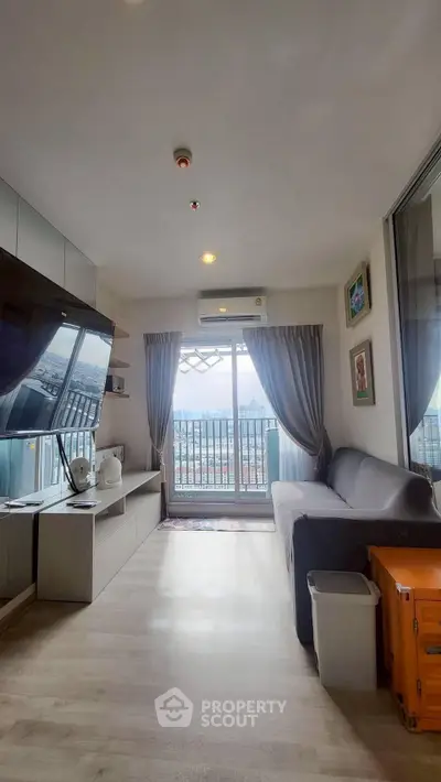 Modern living room with balcony view, sleek furniture, and natural light in urban apartment.