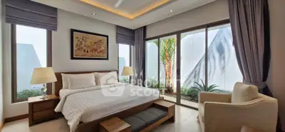 Luxurious bedroom with large windows and elegant decor, offering a serene garden view.
