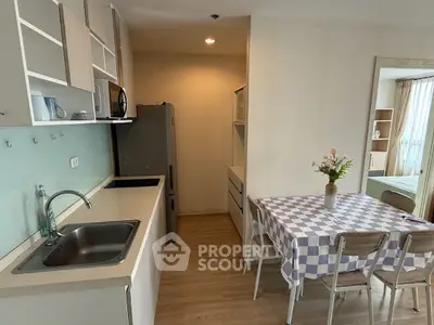 Cozy kitchen with dining area and modern appliances in a stylish apartment.