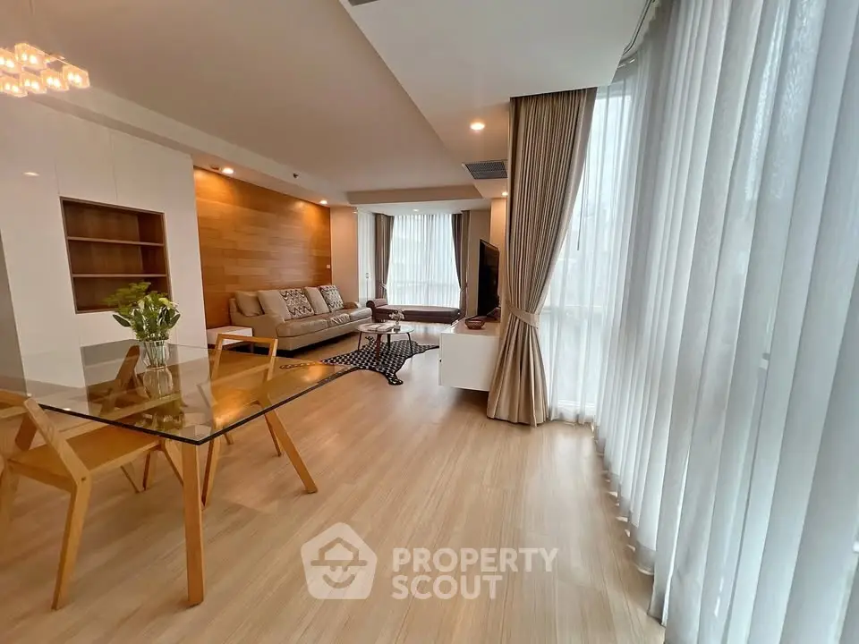 Spacious modern living room with elegant wooden flooring and large windows.