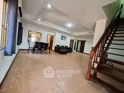 Spacious open-plan living room with elegant staircase and modern furnishings