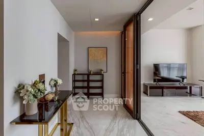 Elegant living room with marble flooring and modern decor, featuring a sleek TV unit and stylish furniture.