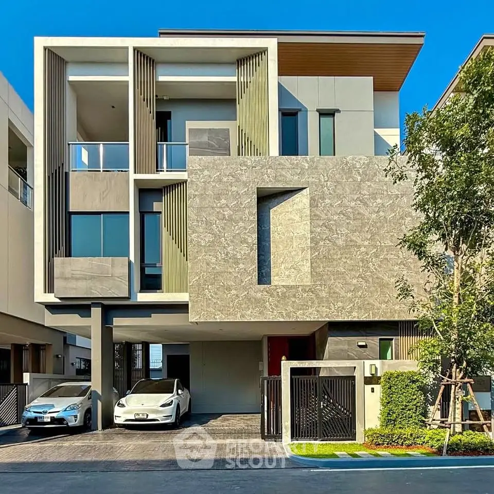 Modern luxury three-story house with sleek design and two-car garage in upscale neighborhood.