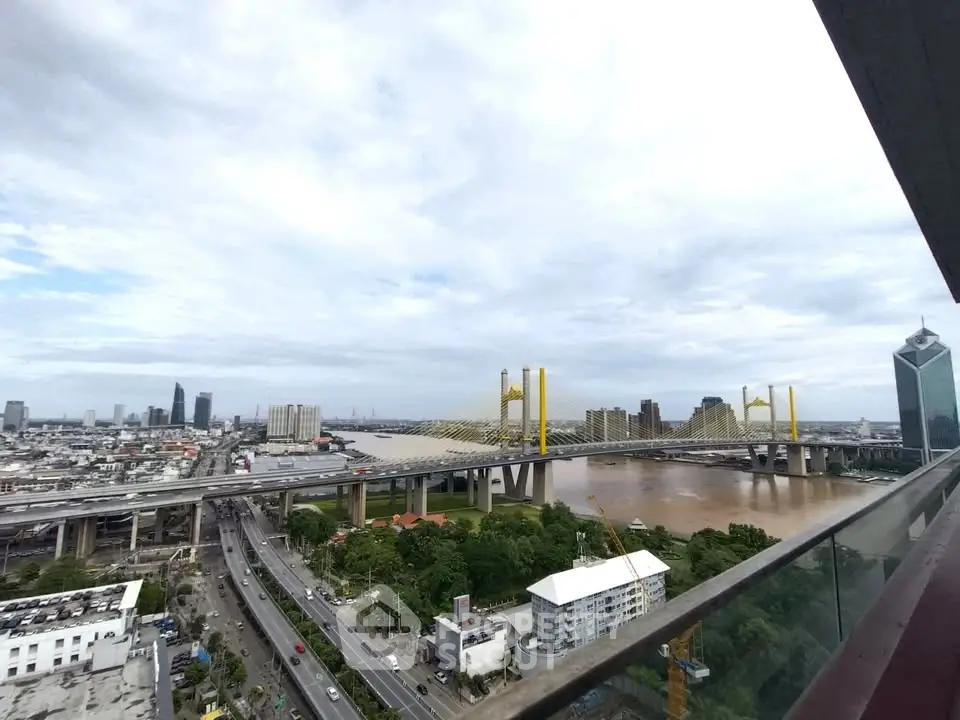 Stunning cityscape view from high-rise balcony overlooking river and bridge