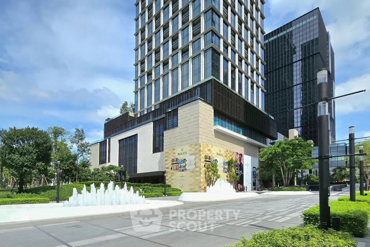 Modern high-rise building with sleek design and lush landscaping