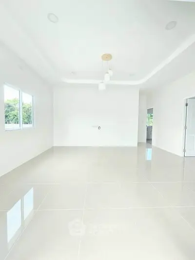 Spacious and bright living room with modern lighting and large windows.