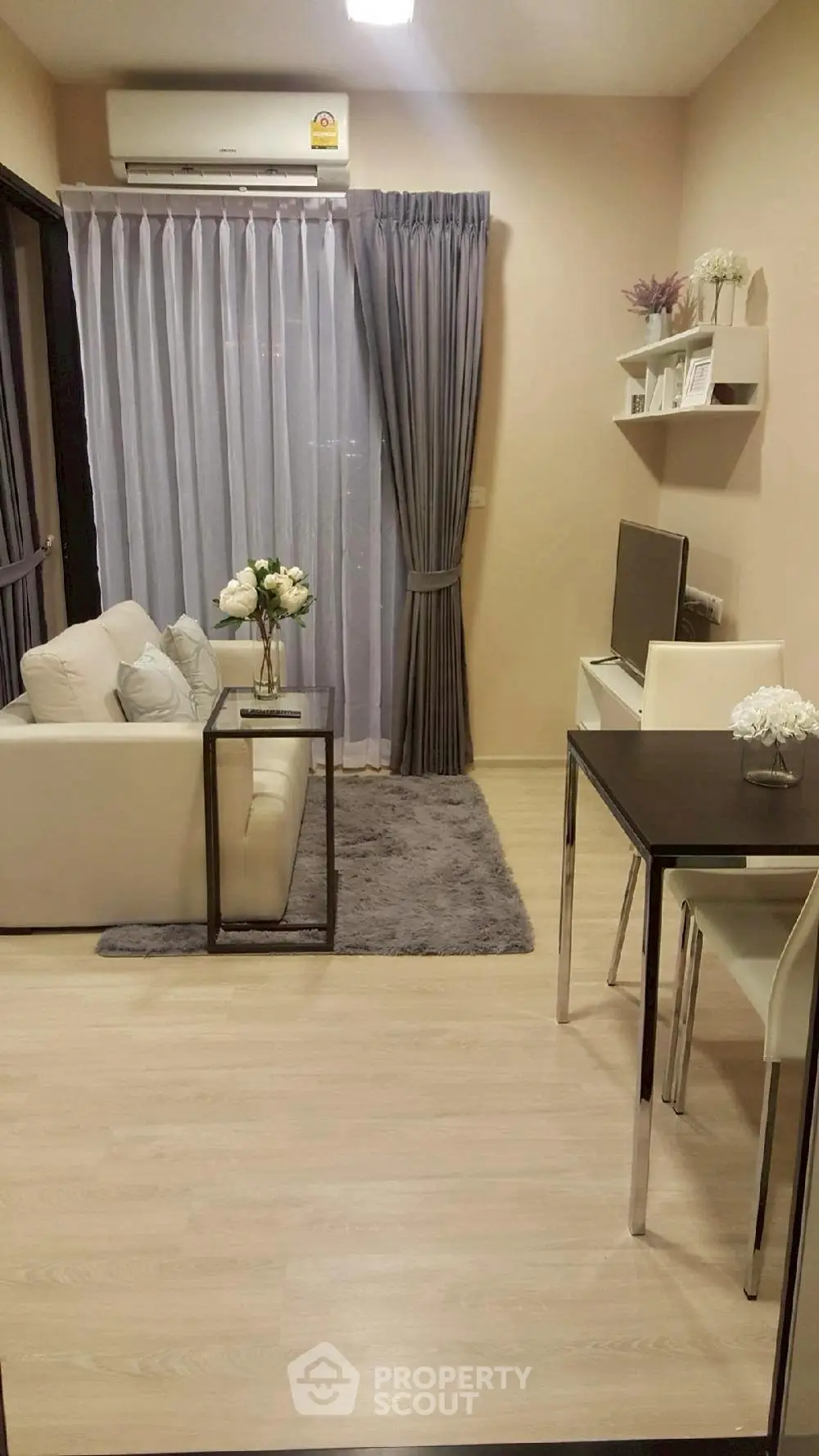 Modern living room with elegant decor and cozy ambiance, featuring a sleek air conditioner and stylish furniture.