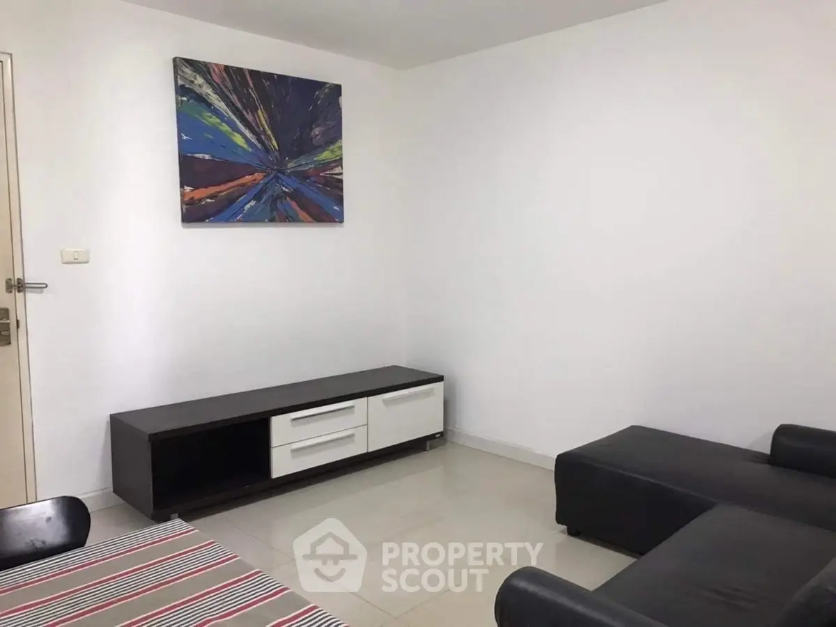 Modern living room with sleek furniture and abstract art on the wall.