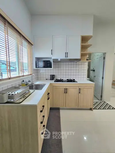 Modern kitchen with sleek cabinetry and gas stove in bright apartment