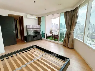 Spacious bedroom with city view and large windows in modern apartment
