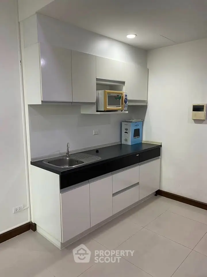 Modern compact kitchen with sleek cabinetry and built-in appliances in a minimalist design.