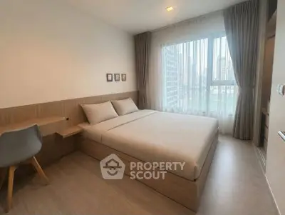 Modern bedroom with city view, featuring sleek wooden furniture and large window for natural light.