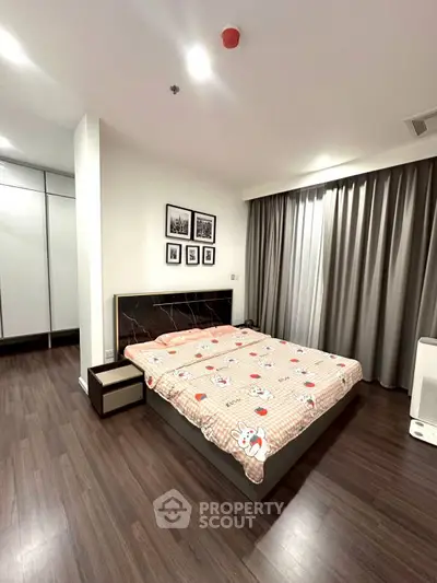 Spacious bedroom with modern decor and large windows in a stylish apartment.