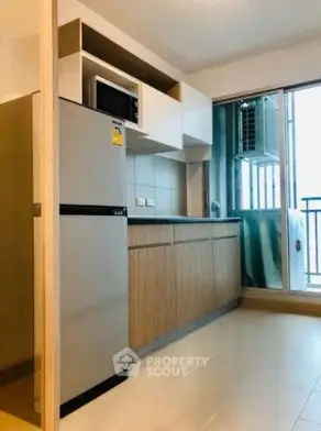 Modern kitchen with balcony access and sleek appliances in a stylish apartment.