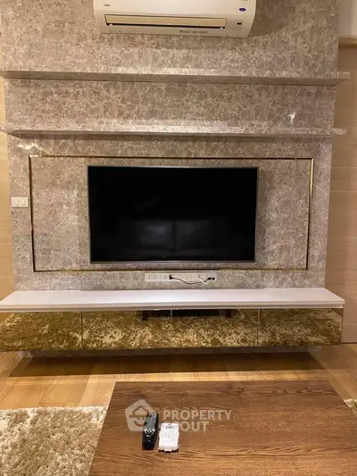 Luxurious living room with elegant TV setup and modern air conditioning unit.