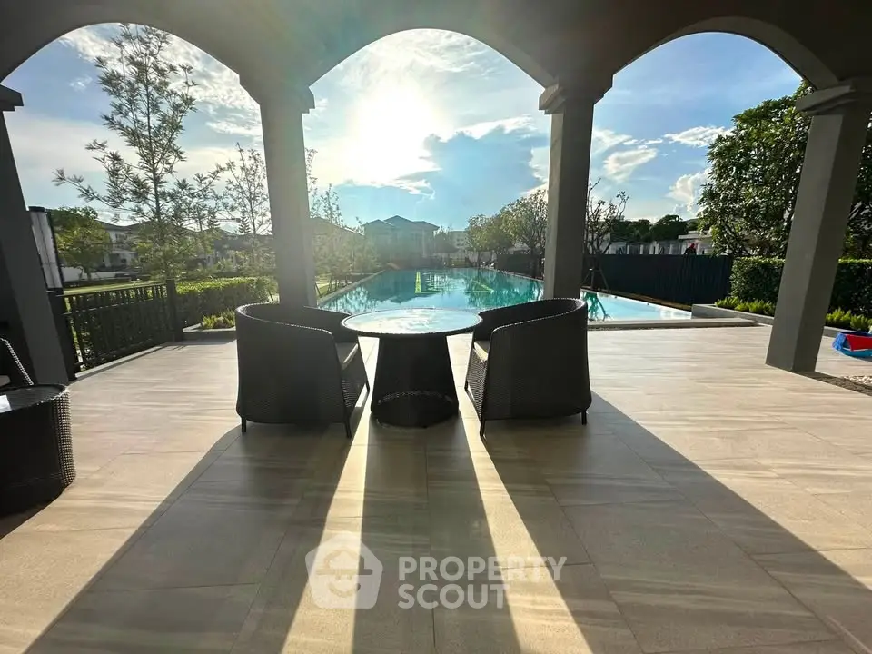 Luxurious poolside patio with elegant seating and stunning sunset view, perfect for relaxation and entertaining.