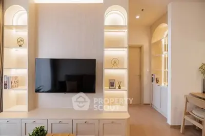 Modern living room with built-in shelves and wall-mounted TV, featuring elegant lighting and stylish decor.
