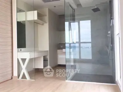 Modern bathroom with glass shower and wooden flooring in a luxury apartment.