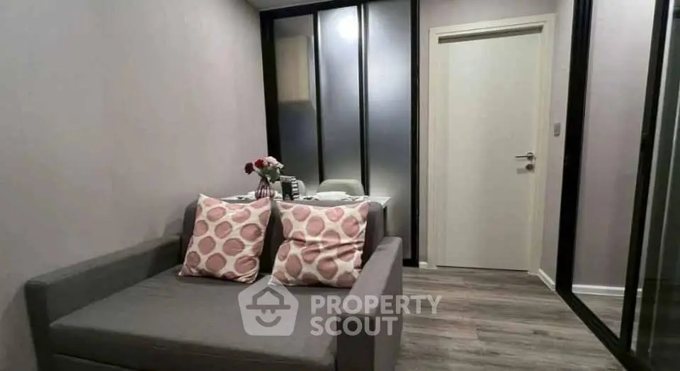 Cozy modern living room with stylish gray sofa and decorative pillows, perfect for relaxation.