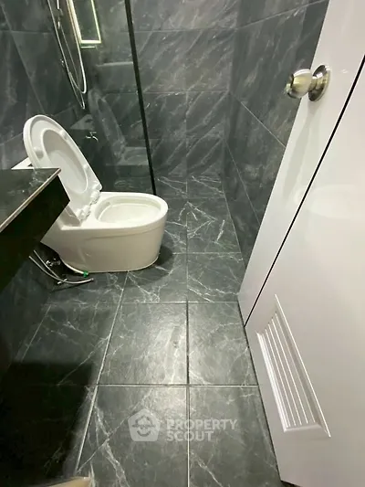Modern bathroom with sleek black marble tiles and contemporary fixtures.