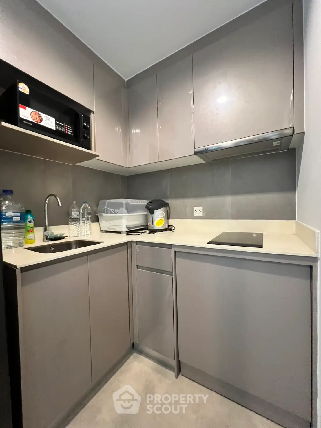 Modern compact kitchen with sleek cabinetry and built-in appliances in a stylish apartment.