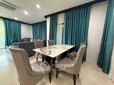 Elegant dining area with marble table and plush chairs in a modern living room setting.