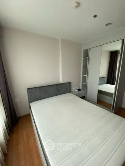 Modern bedroom with sleek design and ample natural light, featuring a comfortable bed and built-in wardrobe.