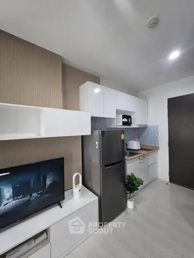Modern kitchen with sleek appliances and stylish cabinetry in a contemporary apartment.