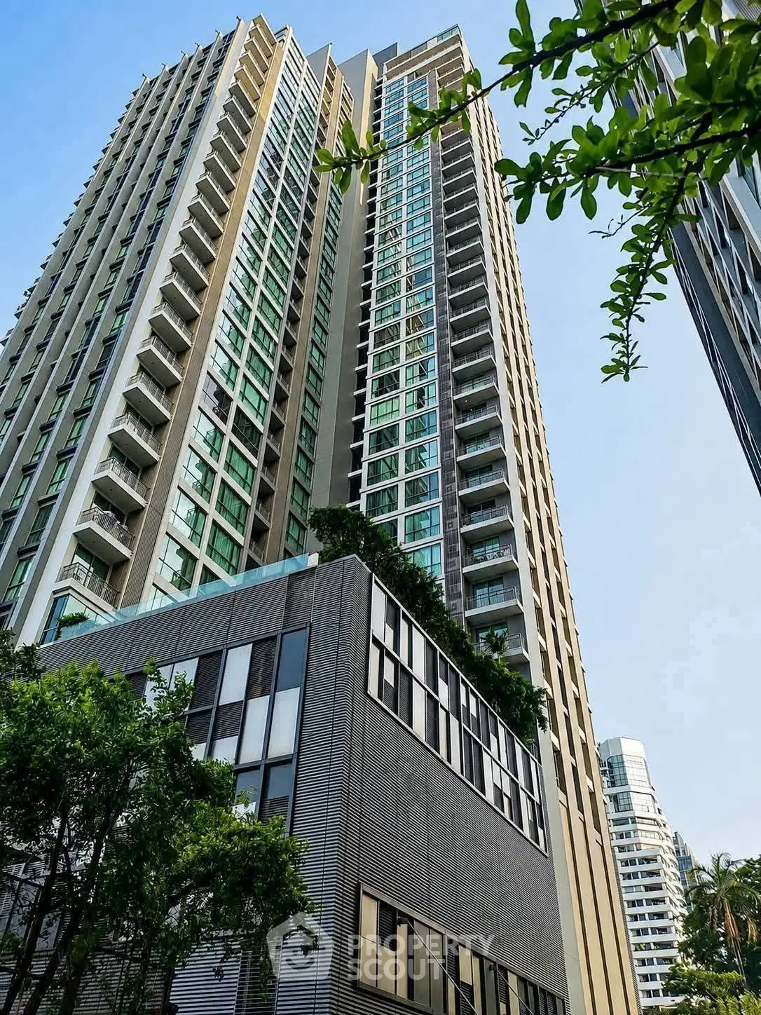 Stunning modern high-rise building with lush greenery and sleek architectural design.